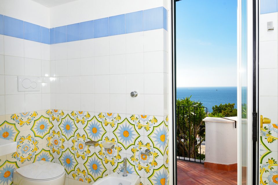 Bagno con maioliche gialle, vasca e doccia