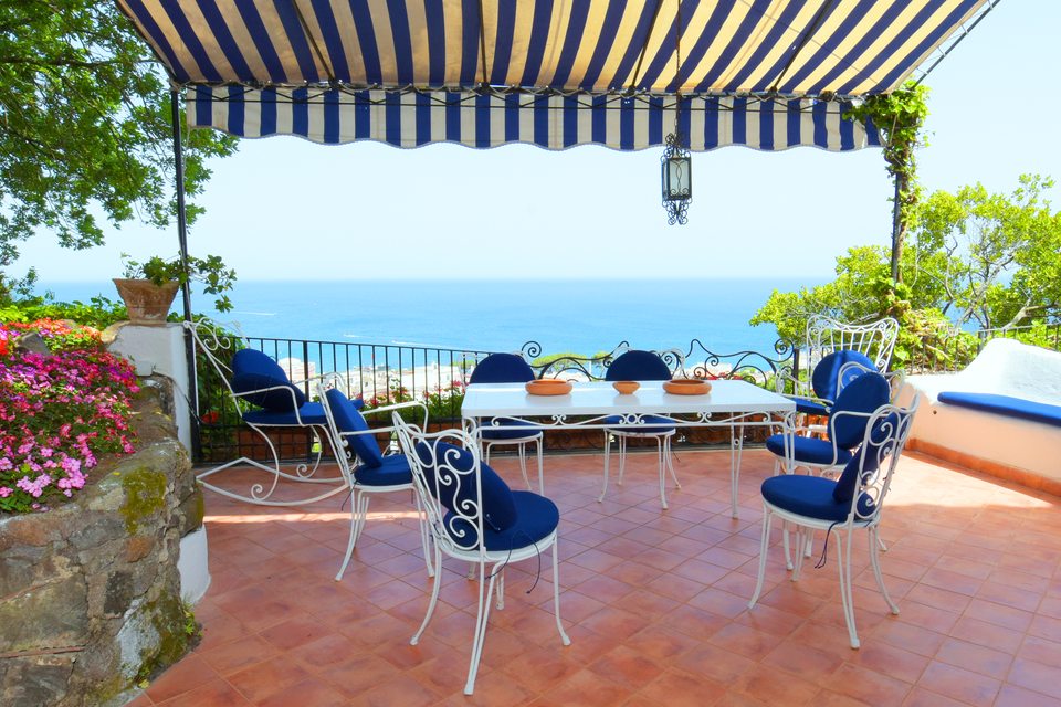 Tavolo in terrazza sotto la tenda a righe